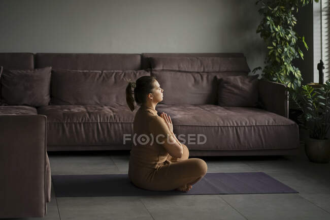 Körperpositive Frau praktiziert Yoga zu Hause. — Stockfoto