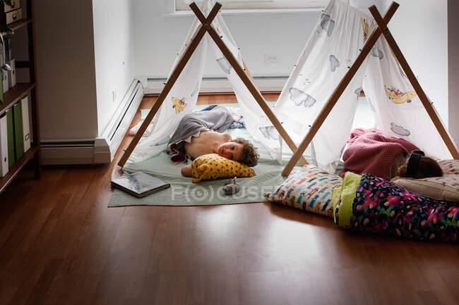 Dos niños durmiendo dentro en tiendas de campaña - foto de stock