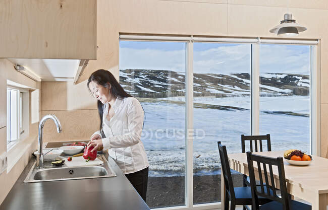 Mujer preparando comida dentro de la casa de vacaciones islandesa - foto de stock