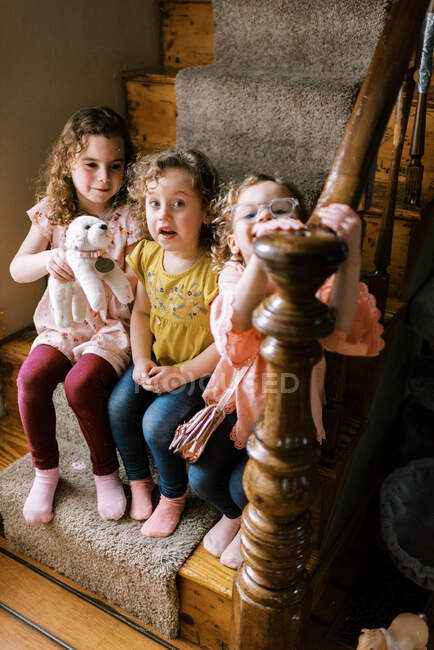 Счастливые маленькие девочки играют вместе на лестнице — стоковое фото
