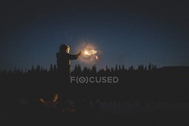 Tween  Boy's Face Is illuminated by a glowing sparkler at Twilight — Stock Photo
