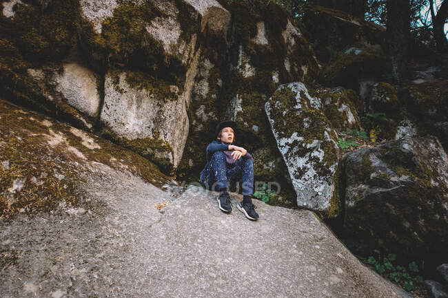 Un jeune garçon se repose sur un rocher alors qu'il fait de la randonnée à Yosemite — Photo de stock