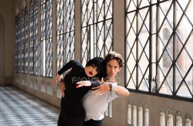 Uomo premendo donna vicino e gesticolando durante le prove di danza latina in sala da ballo — Foto stock