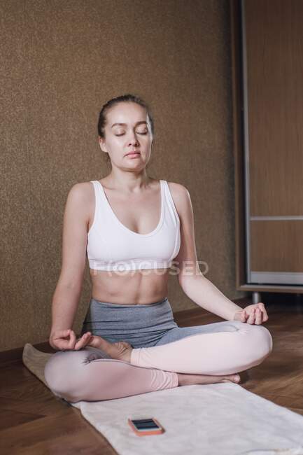 Portrait of woman meditating at home — Stock Photo