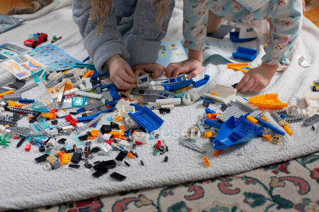 Siblings playing with toy bricks on the floor — Stock Photo