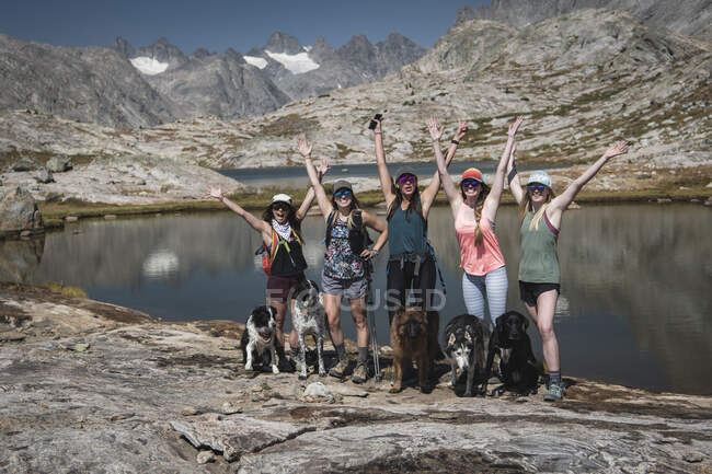 Carefree female friends with dogs standing at Titcomb Basin during vacation — Stock Photo