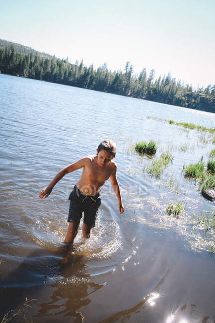 Jeune homme en veste noire et maillot de bain sur la plage — Photo de stock