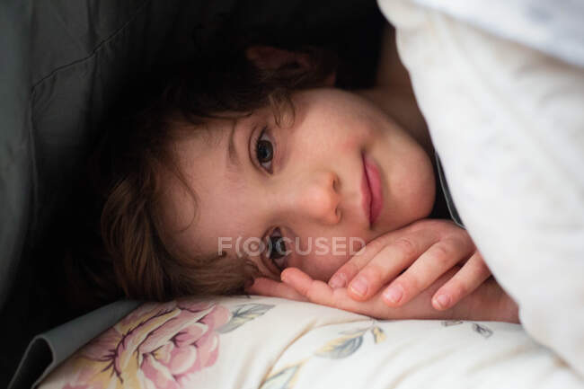 Vista frontal de um menino alegre deitado — Fotografia de Stock