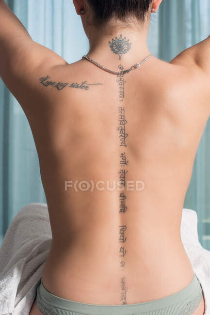 Jeune femme avec dos nu se préparant pour le massage thérapeutique — Photo de stock