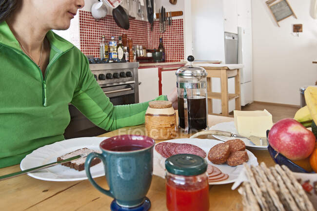 Mulher tomando café da manhã na mesa da cozinha na Islândia — Fotografia de Stock