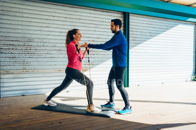 Особистий тренер навчає 49-річну жінку, як правильно виконувати вправи . — стокове фото