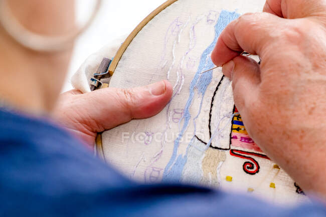 Close-up das mãos de uma mulher idosa bordando em um tecido. Tr — Fotografia de Stock