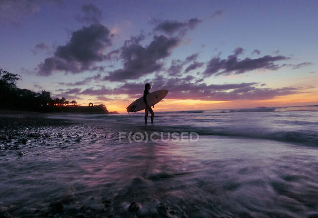 Surfer ragazza silhouette contro tramonto colorato — Foto stock