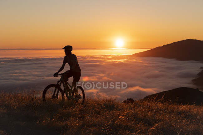 Silhouette of a man with a backpack on the mountain — Stock Photo