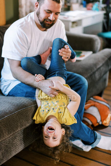 A father and his daughter playing together in the living room — Stock Photo