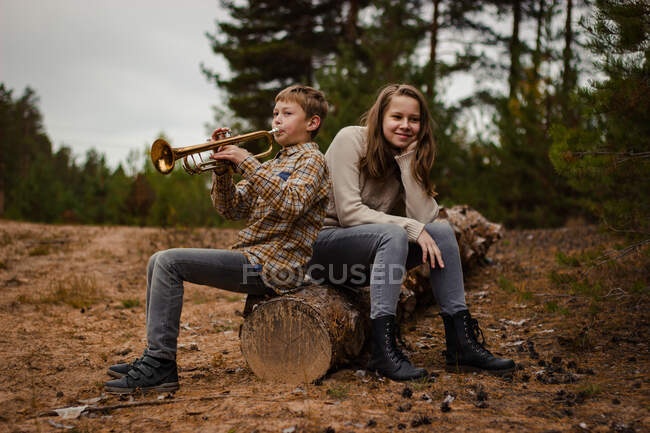 Мальчик и девочка, брат и сестра, подростки играют на трубе и скрипке — стоковое фото