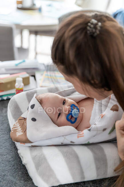 Mother staring at baby boy wrapped in blankets. — Stock Photo