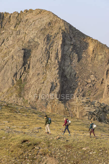 Male and female friends hiking on mountain during vacation — Stock Photo