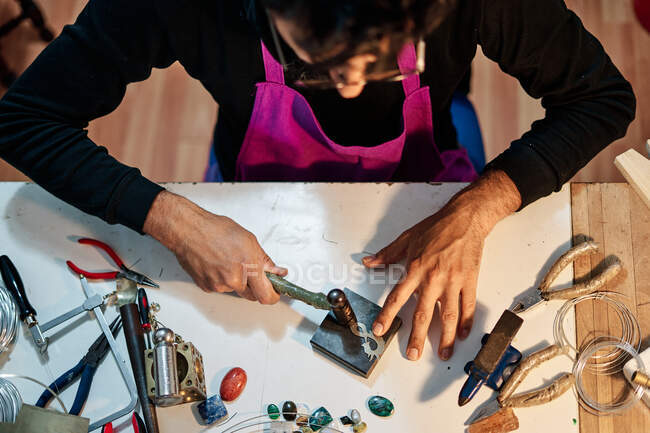Foto aerea del gioielliere artigiano che lavora il gioiello sul tavolo da lavoro — Foto stock