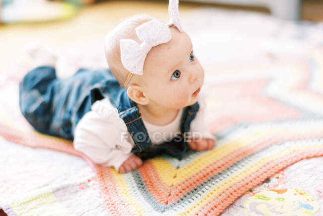 Bebé niña en una manta practicando apoyo en la cabeza durante el tiempo de la panza - foto de stock