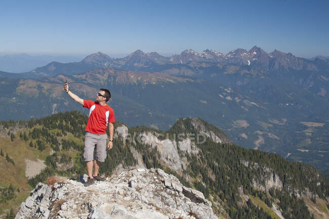 Man looks for phone connection while hiking in the mountains. — Stock Photo