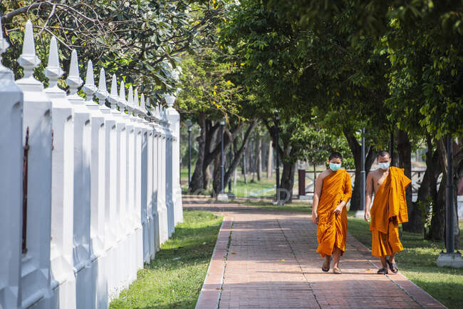 Due monaci buddisti con maschera al tempio di Bangkok — Foto stock