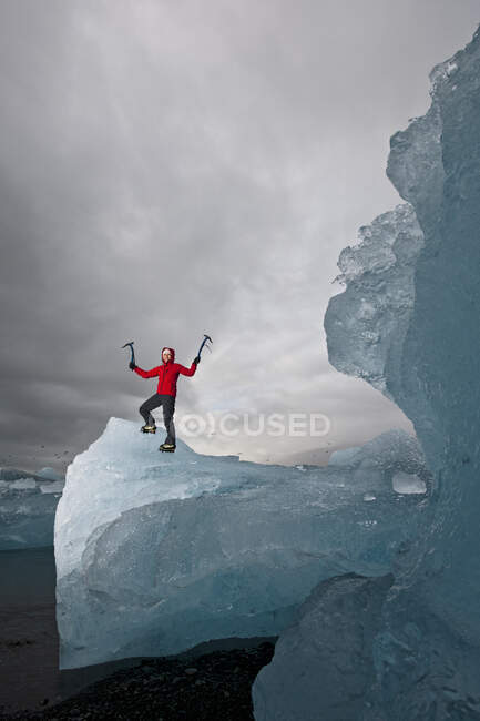 Женщина, взбирающаяся на айсберг на южном побережье Исландии с помощью ножа для колки льда — стоковое фото