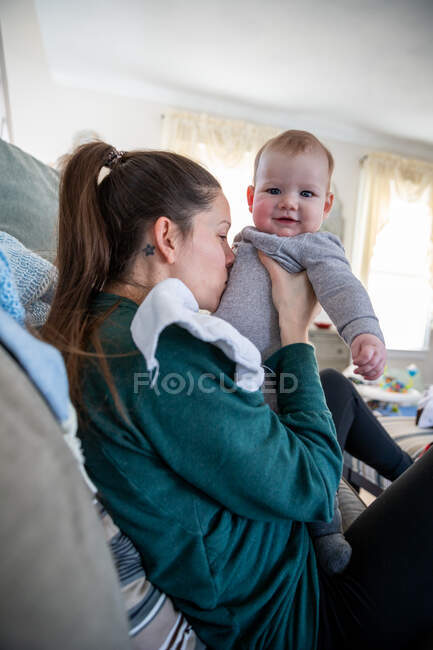 Playful mother holding her happy baby boy. — Stock Photo