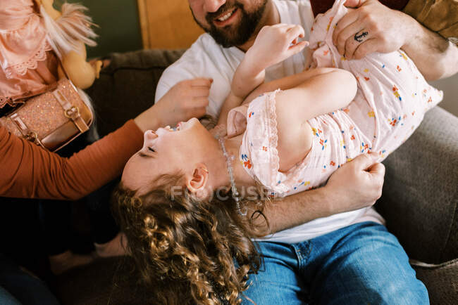 Щаслива молода сім'я з п'яти сміється і грає разом вдома — стокове фото
