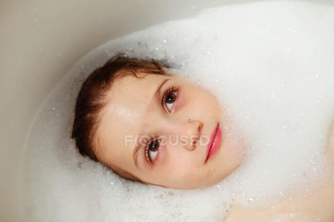 Вид сверху на веселого мальчика в ванной — стоковое фото