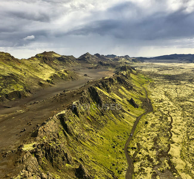 Luftaufnahme von Bergen in Straßennähe und trockenem Gelände an bewölkten Tagen in Island — Stockfoto