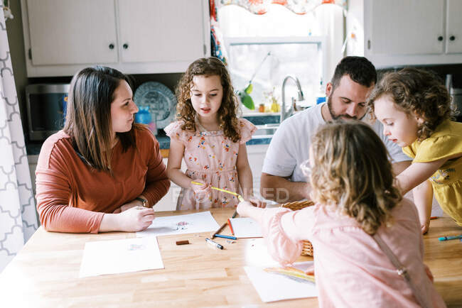 Familia de 5 para colorear y pasar tiempo juntos en la mesa de la cocina - foto de stock