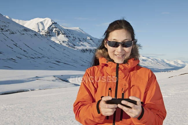 Frau schreibt SMS auf ihrem Smartphone in den Bergen von Nordisland — Stockfoto