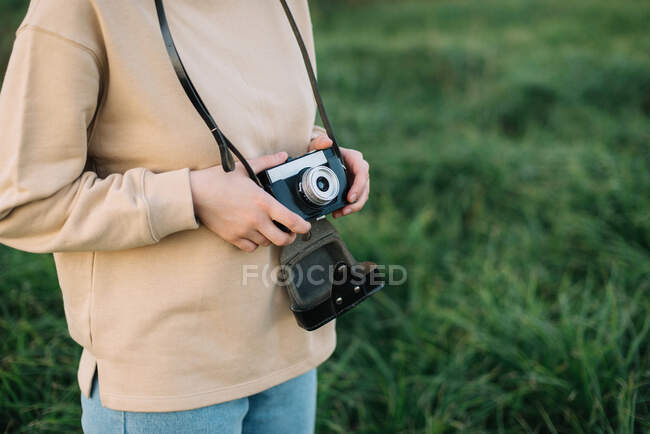 Mulher bonita segurando câmera de filme em um campo — Fotografia de Stock