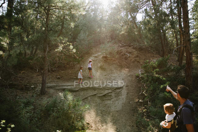 Pai apontando filhas a direção certa em uma caminhada natureza caminhada — Fotografia de Stock