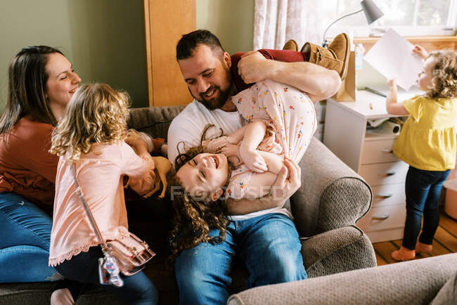 Glückliche junge fünfköpfige Familie lacht und spielt gemeinsam zu Hause — Stockfoto