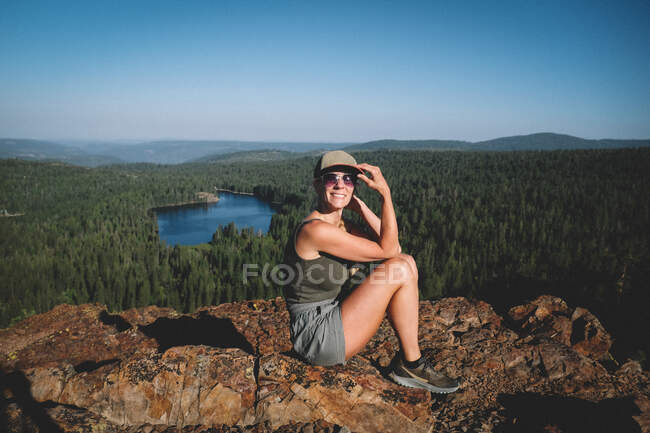 La mujer posa en la escénica cima montañesa temprano en la mañana - foto de stock
