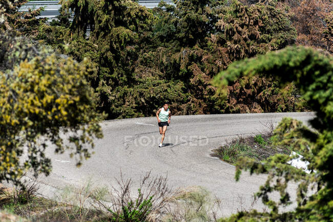 Latin American man running on a winding road — Stock Photo
