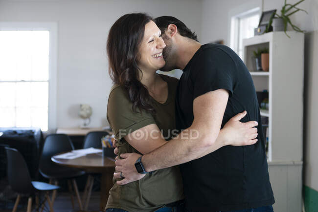 Man kissing a laughing woman, embracing. — Stock Photo
