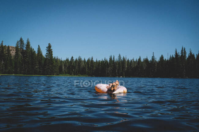 Kleine Füße aus einem Donut Floatie an einem heißen Sommertag — Stockfoto