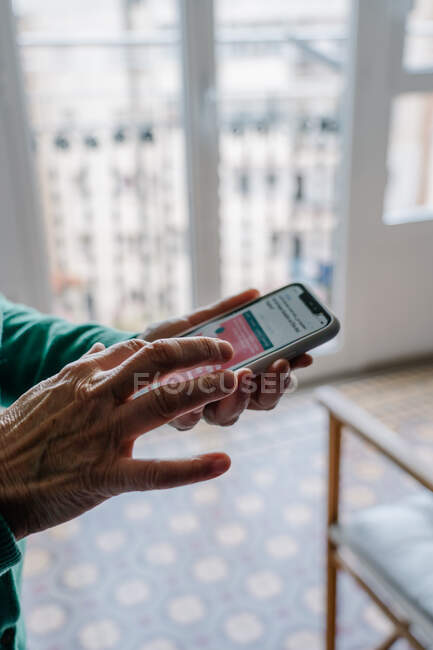 Mão de mulher velha usando um telefone celular — Fotografia de Stock