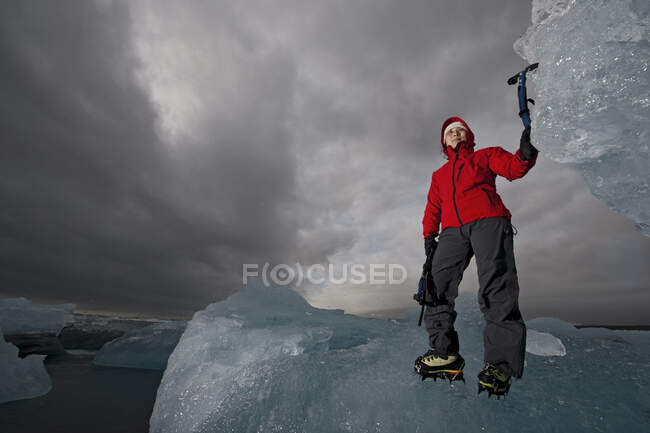 Frau besteigt Eisberg an der Südküste Islands mit Eispflücker — Stockfoto