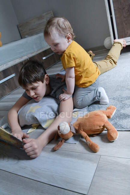 Brother reading book to his little sister — Stock Photo