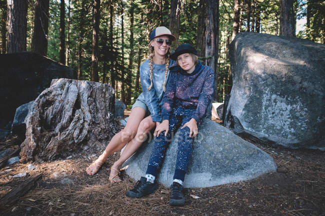 Madre e hijo posan para una foto mientras acampan en el bosque - foto de stock