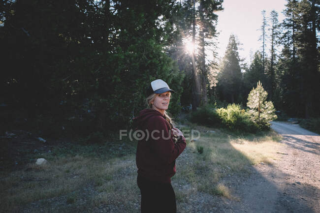 Pretty Blonde Girl comienza la caminata matutina en un camino de tierra en las Sierras - foto de stock