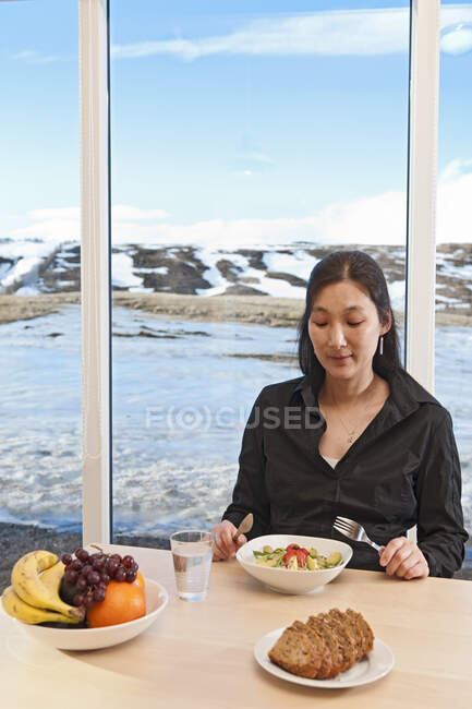 Korean woman eating salad inside country side house — Stock Photo