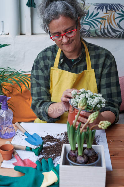 Foto vertical da mulher sorridente preparando plantas de jardim em casa na primavera — Fotografia de Stock