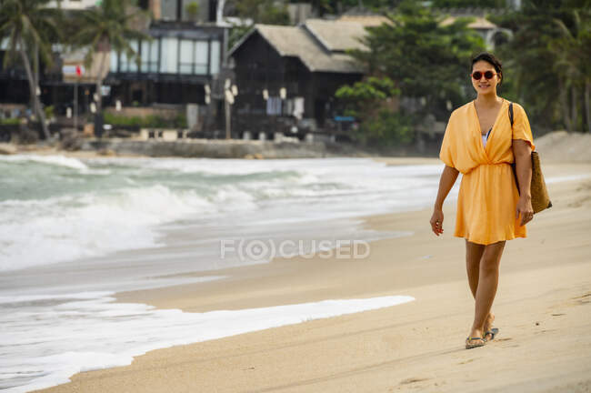 Hermosa mujer joven en un vestido blanco en la playa - foto de stock