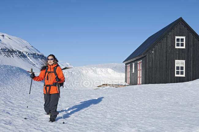 Woman setting off for a hike from ski cottage in Iceland — Stock Photo