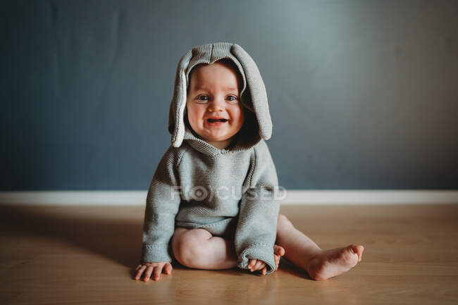 Linda niña en un suéter caliente sobre un fondo gris - foto de stock
